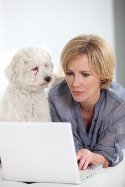Frau mit Hund vor dem Computer